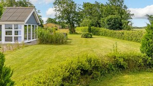 A house with a large lawn, a conservatory, and a garden with various plants and trees. - "Thrine" - 24km from the sea by Interhome (Bredebro)