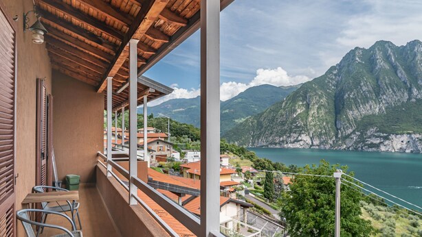Un balcon offrant une vue sur un paysage montagneux et un plan d’eau.