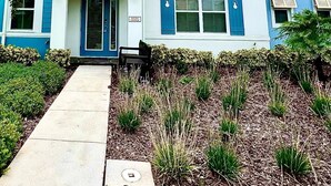 A two-story house with blue shutters and a front porch. - Your Perfect Family Retreat! (Kissimmee)