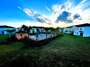 A residential area with houses, a swimming pool, and a grassy lawn. - Your Perfect Family Retreat! (Kissimmee)