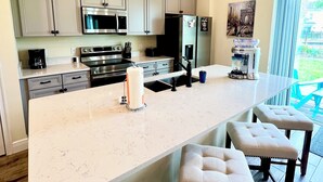 A modern kitchen with a large island, stainless steel appliances, and a view of the outdoors. - Your Perfect Family Retreat! (Kissimmee)