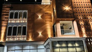 Un edificio moderno con una fachada distintiva que presenta patrones geométricos y una serie de ventanas arqueadas.