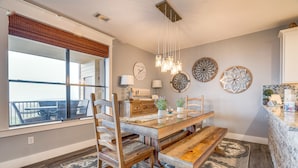 A dining area with a wooden table, chairs, and a bench. There are decorative wall plates and a chandelier. - Jonestown Condo on Lake Travis w/ 2 Balconies! (Jonestown)