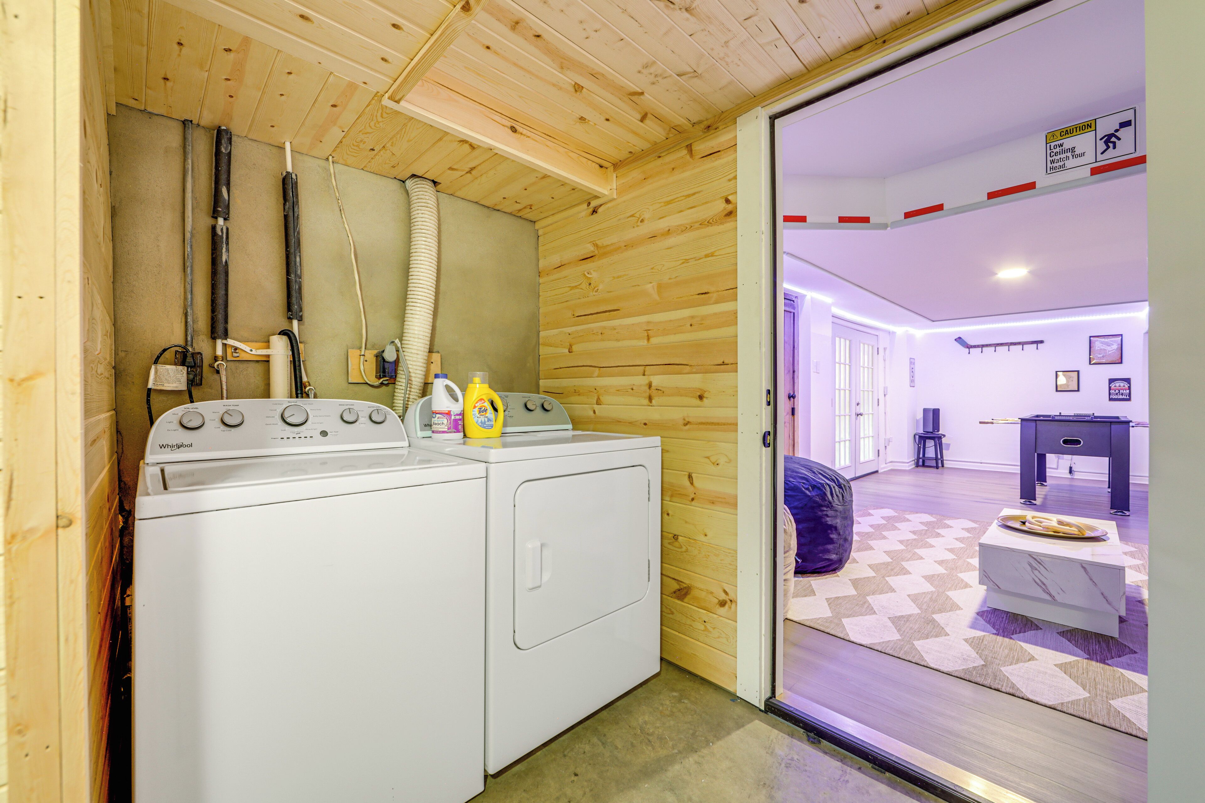 A laundry room with two white Whirlpool washers, a dryer, and a vent hose.