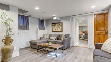 A modern living room with a grey sofa, a wooden coffee table, and a large world map on the wall.