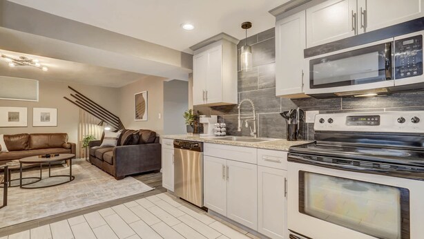 A modern kitchen with white cabinetry, stainless steel appliances, and a built-in oven. - Blackstone Hideaway! Downtown Lower-Level Apt! (Colorado Springs)