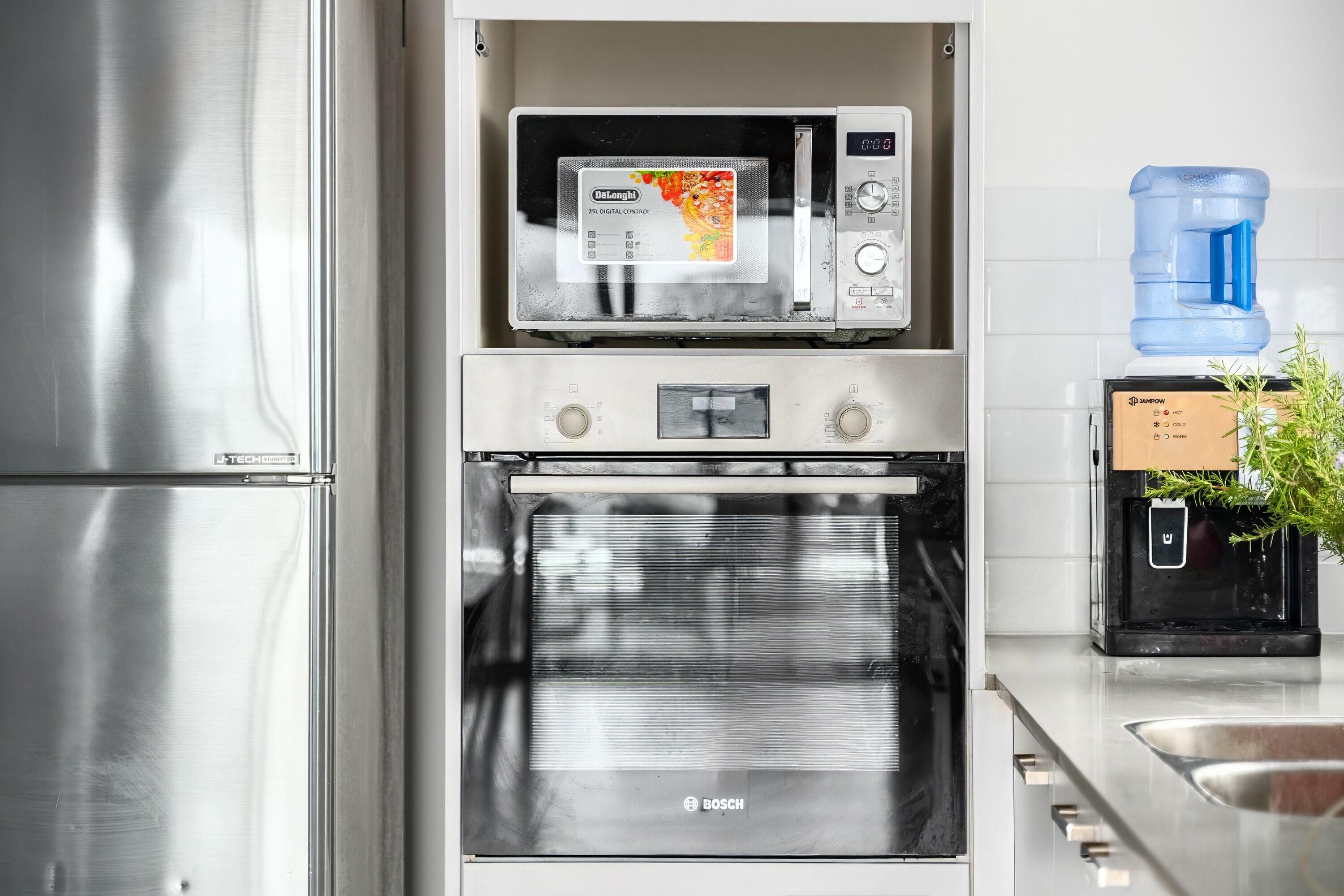 Een keuken met een magnetron, oven en koffiezetapparaat.