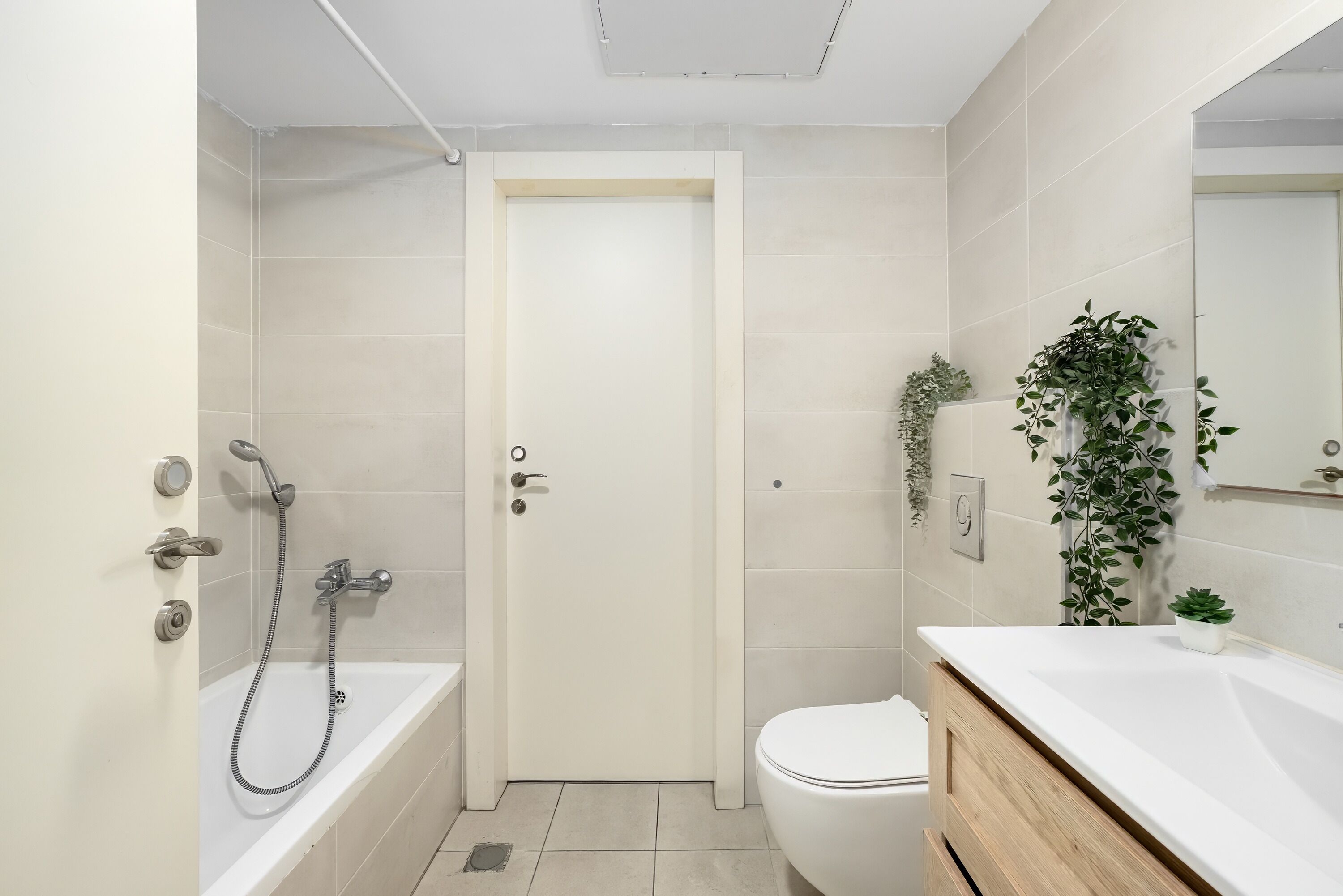 A modern bathroom with a bathtub, toilet, and sink.
