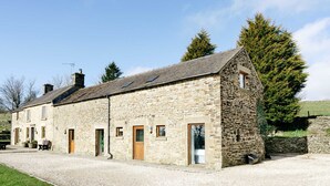 A stone building with multiple doors and windows, a gravel driveway, and a large tree in the background. - Lapwing Barns, large rural farmhouse with games room, perfect for all types of groups. (Longnor)