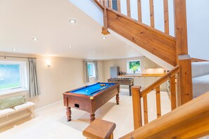 A spacious living area with a pool table, a foosball table, and a kitchen in the background. - The Star in Taddington, 9 bedroom exclusive venue. Close to Buxton and Bakewell. (Buxton)