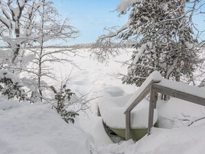 Área externa coberta de neve, com uma escadaria de madeira descendo.