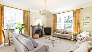 A spacious living room with a fireplace, comfortable seating, and large windows. - Victorian country house with 9 ensuite bedrooms, nestled in a pretty hamlet (Buxton)