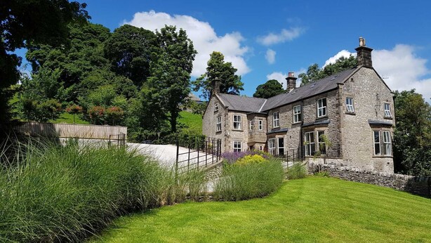 A stone house with multiple windows and a well-maintained lawn. - Victorian country house with 9 ensuite bedrooms, nestled in a pretty hamlet (Buxton)