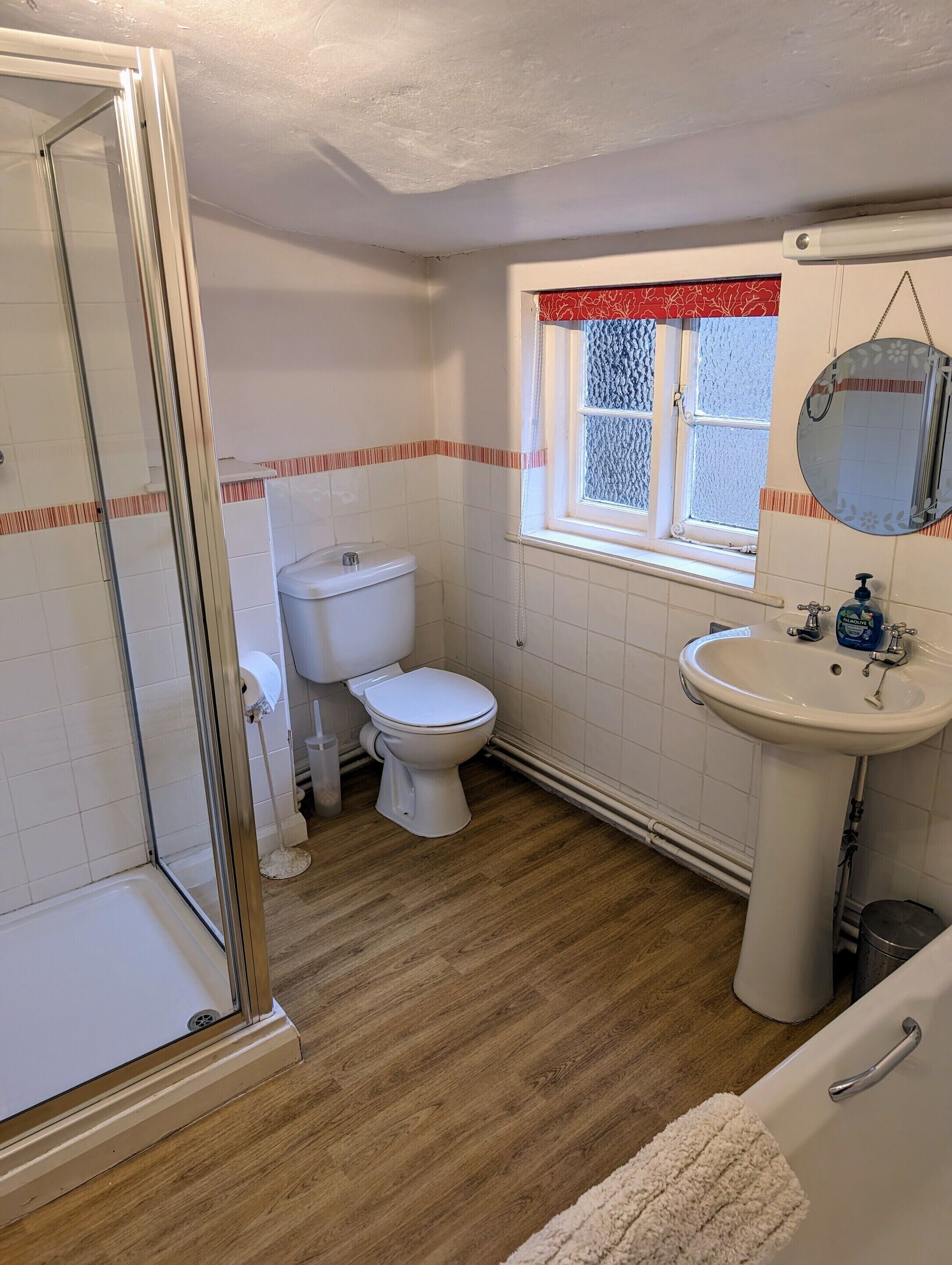 A bathroom with a toilet, sink, and shower area.
