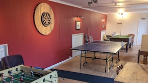 A room with a foosball table, a dartboard, and a pool table. - Bartholomew Arms (Towcester)