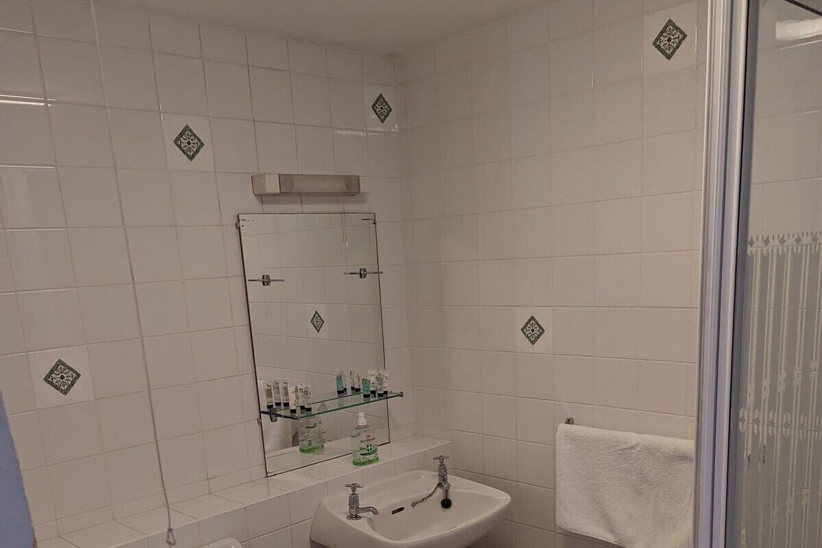A bathroom with a toilet, sink, and shower.