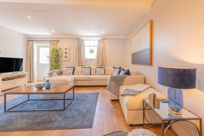 Ein modernes Wohnzimmer mit einer Couch, einem Couchtisch und einem Fernseher.