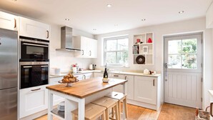 A modern kitchen with white cabinetry, a wooden countertop, and a stainless steel refrigerator. - A cosy country cottage in the village of Curbar with amazing views of Curbar Edge (Curbar)