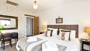 Une chambre d’hôtel équipée d’un lit, d’un bureau, d’une chaise, d’un miroir, d’une horloge et d’une lampe.