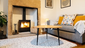 A cozy living room with a fireplace, a sofa, a coffee table, and a rug. - Cosy 2 bed cottage nestled in the village of Bradwell, close to the Hope Valley (Bradwell)