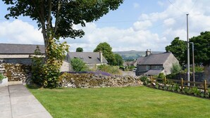 A rural village with stone walls, houses with sloped roofs, and a grassy area with a tree. - Cosy 2 bed cottage nestled in the village of Bradwell, close to the Hope Valley (Bradwell)