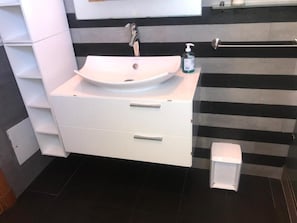 Een haardroger, handdoeken, zeep, toiletpapier