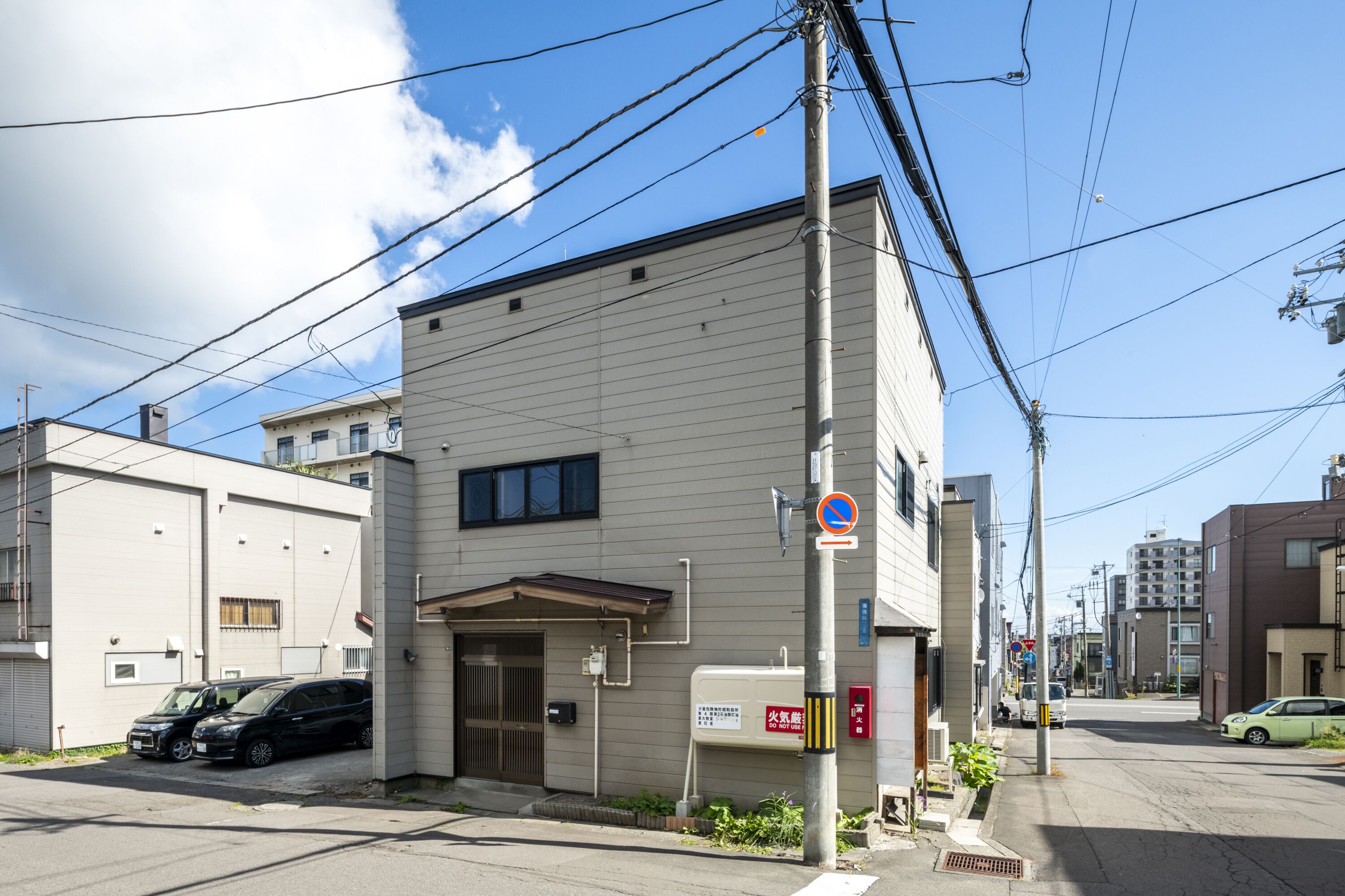 A two-story building with a garage, a water tank, and a no parking sign.