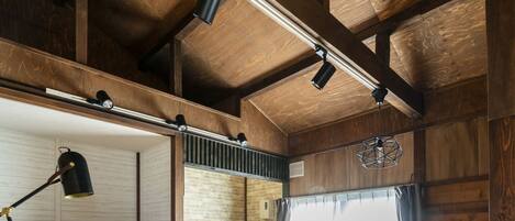 Una habitación acogedora de estilo cabaña, con techo de madera, un sofá, un televisor y una mesita.