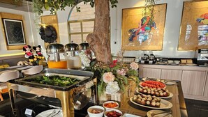A buffet setup with various food items, including salads, fruits, and a salad bar. - Frame Hotel Bangkok (Bangkok)