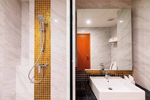 A bathroom with a shower, a sink, and a mirror. - Frame Hotel Bangkok (Bangkok)
