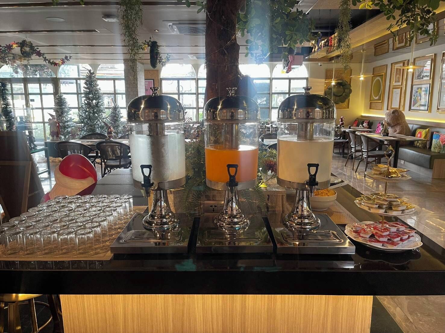 A buffet setup with multiple beverage dispensers and a variety of food items.