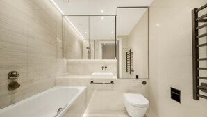 Un baño moderno con bañera, inodoro y lavamanos.