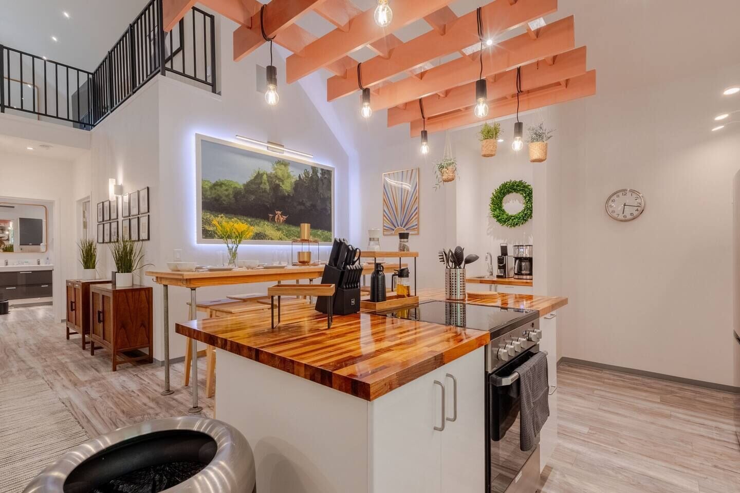 Une cuisine moderne dotée d’un îlot central, de planchers en bois et d’une grande fenêtre offrant une belle vue.