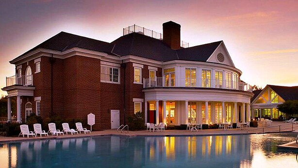 A large, two-story building with a swimming pool in front.