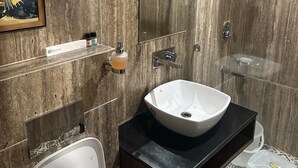 Un baño moderno con un espejo grande, un lavabo a la vista y un inodoro.