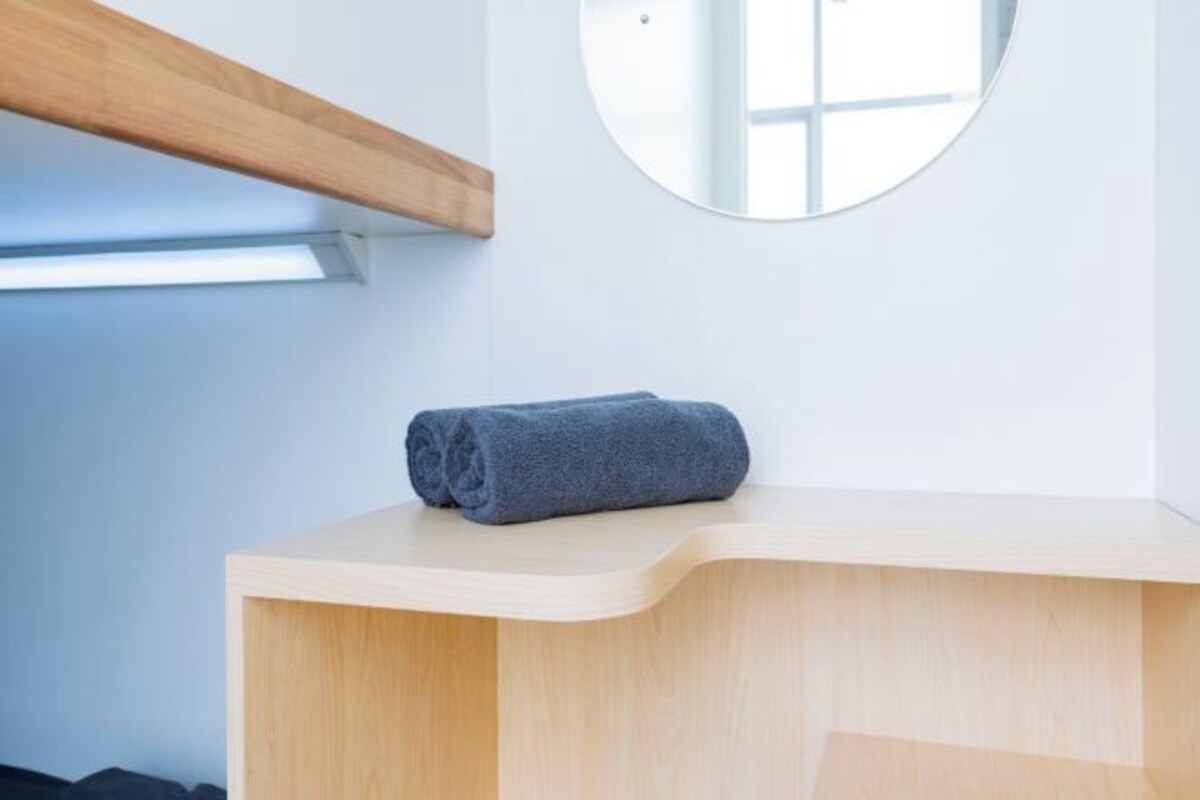 A wooden counter with a towel, a mirror, and a skylight.