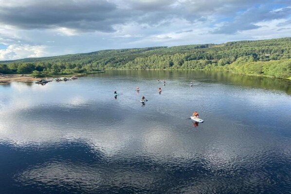 A calm lake surrounded by forested hills.