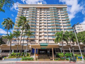 A multi-story hotel with a central entrance, multiple balconies, and surrounding palm trees. - Aloha Surf Waikiki - 5 minute walk to Waikiki beach (Honolulu)