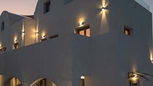 A modern white building with multiple balconies and outdoor seating areas. - The Vine Suites (Santorini)
