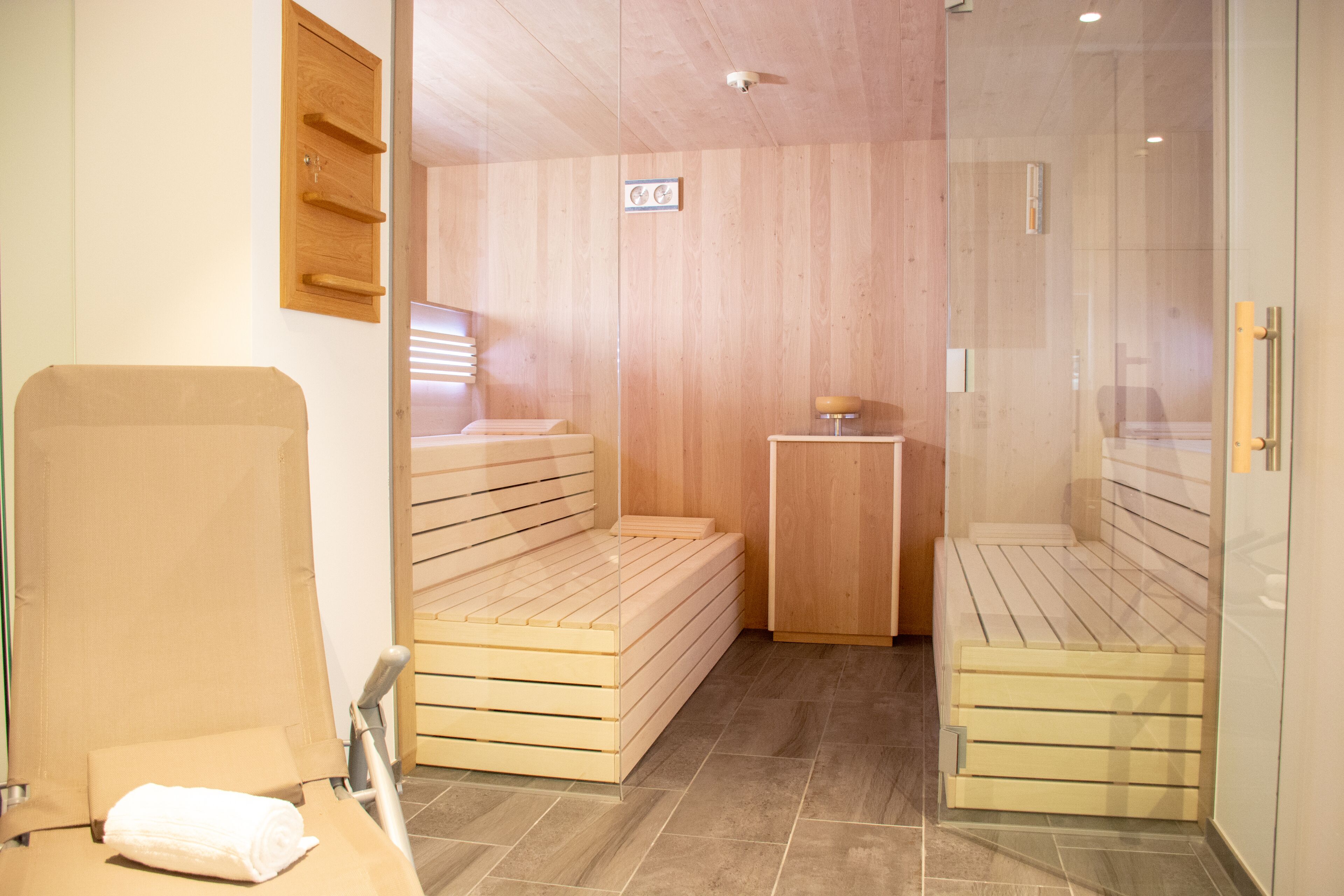 Un cuarto de sauna con bancos de madera y una pequeña mesa.