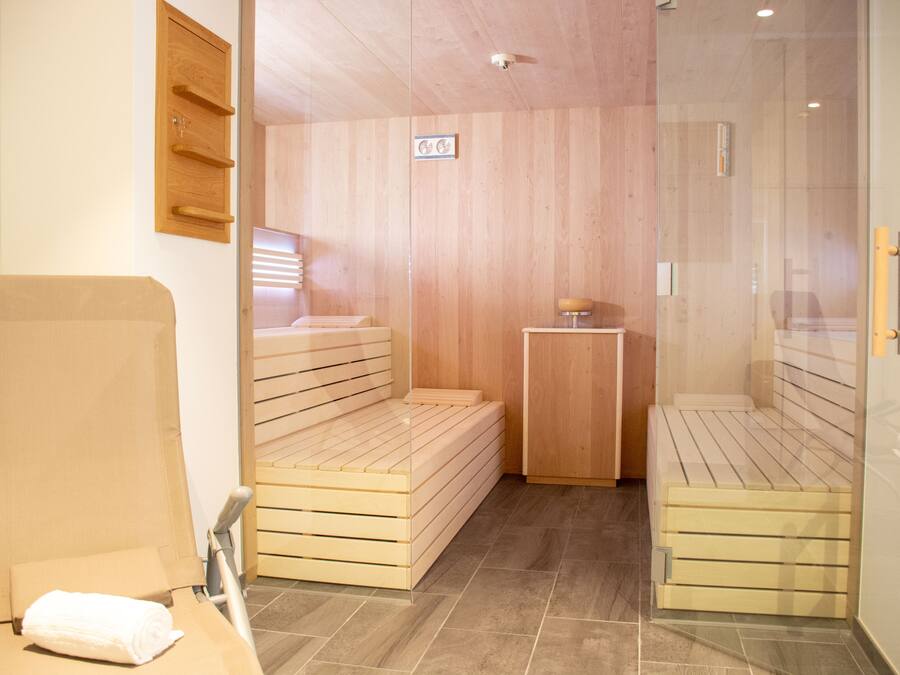 Un cuarto de sauna con bancos de madera y una pequeña mesa.