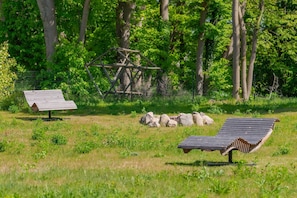 A grassy field with two benches, a wooden structure, and a fence. - Neu Errichtetes Ferienhaus in Ruhiger Wohngegend mit Parkplatz, Sauna und Wlan (Zirchow)