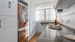 Una cocina moderna con azulejos blancos, un salpicadero de madera y un ventanal que aporta luz natural.