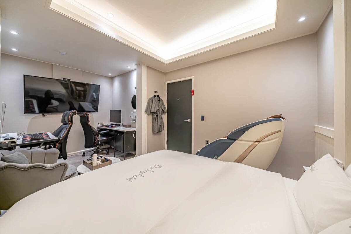 A modern hotel room with a bed, desk, and chair.