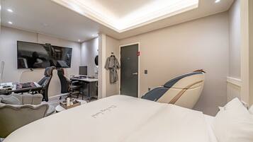 A modern hotel room with a bed, desk, and chair.