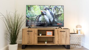 Ett TV-möblemang i trä med en platt-TV som visar en naturdokumentär.