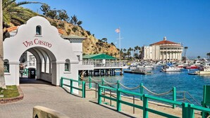 Ein Yachthafen mit vertäuten Booten, ein weißes Gebäude mit der Aufschrift "Via Casino" und im Hintergrund ein großes Gebäude mit rotem Dach.