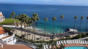 Ein Resort mit Pool, Palmen und Meerblick.