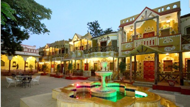 A courtyard with a fountain, outdoor seating, and a building with traditional architecture. - Chokhi Dhani Indore (Indore)