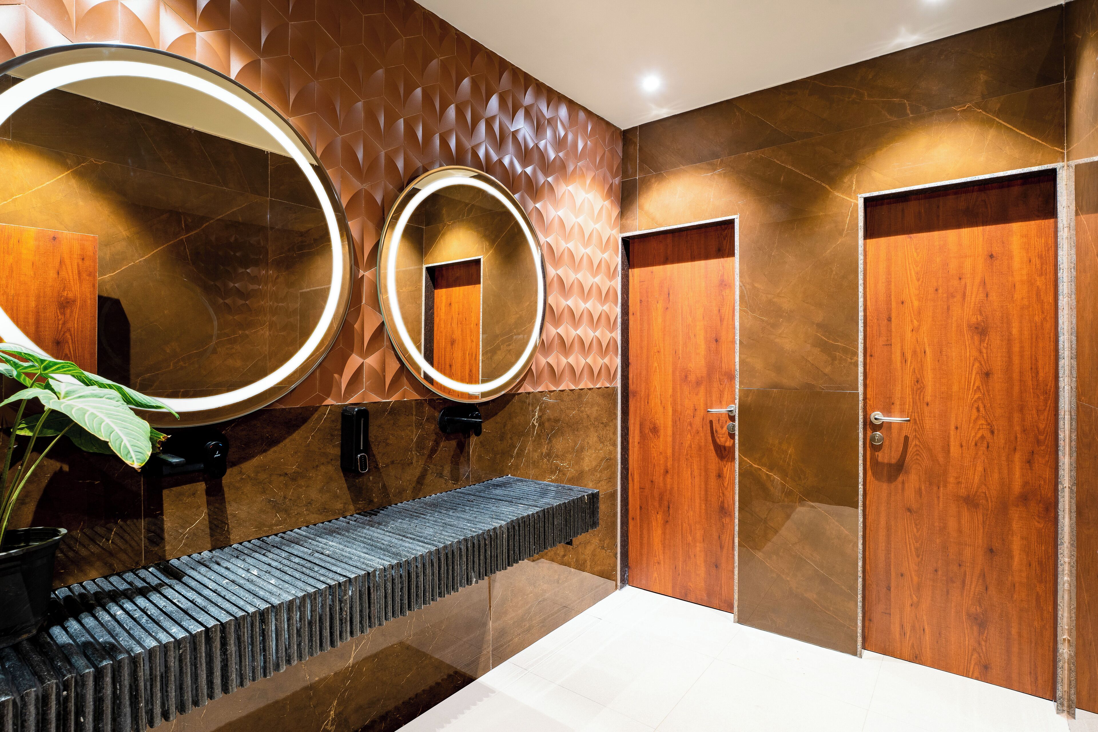 Une salle de bain moderne avec un grand miroir, un lavabo et une porte en bois.